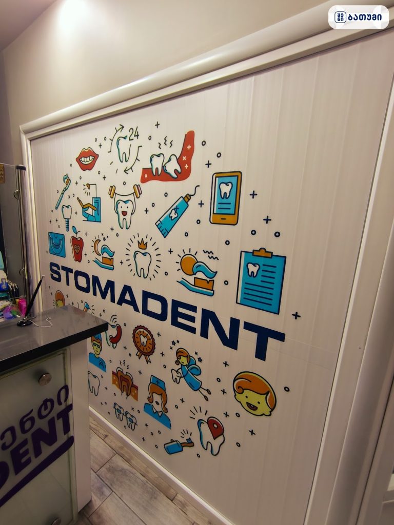 Door or wall panel with 'STOMADENT' branding and colorful dental-themed illustrations.