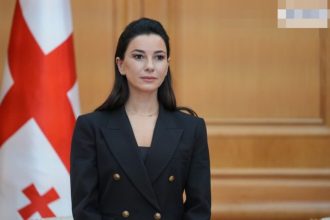 ოფიციალური პირი საქართველოს დროშის ფონზე — ბათუმი